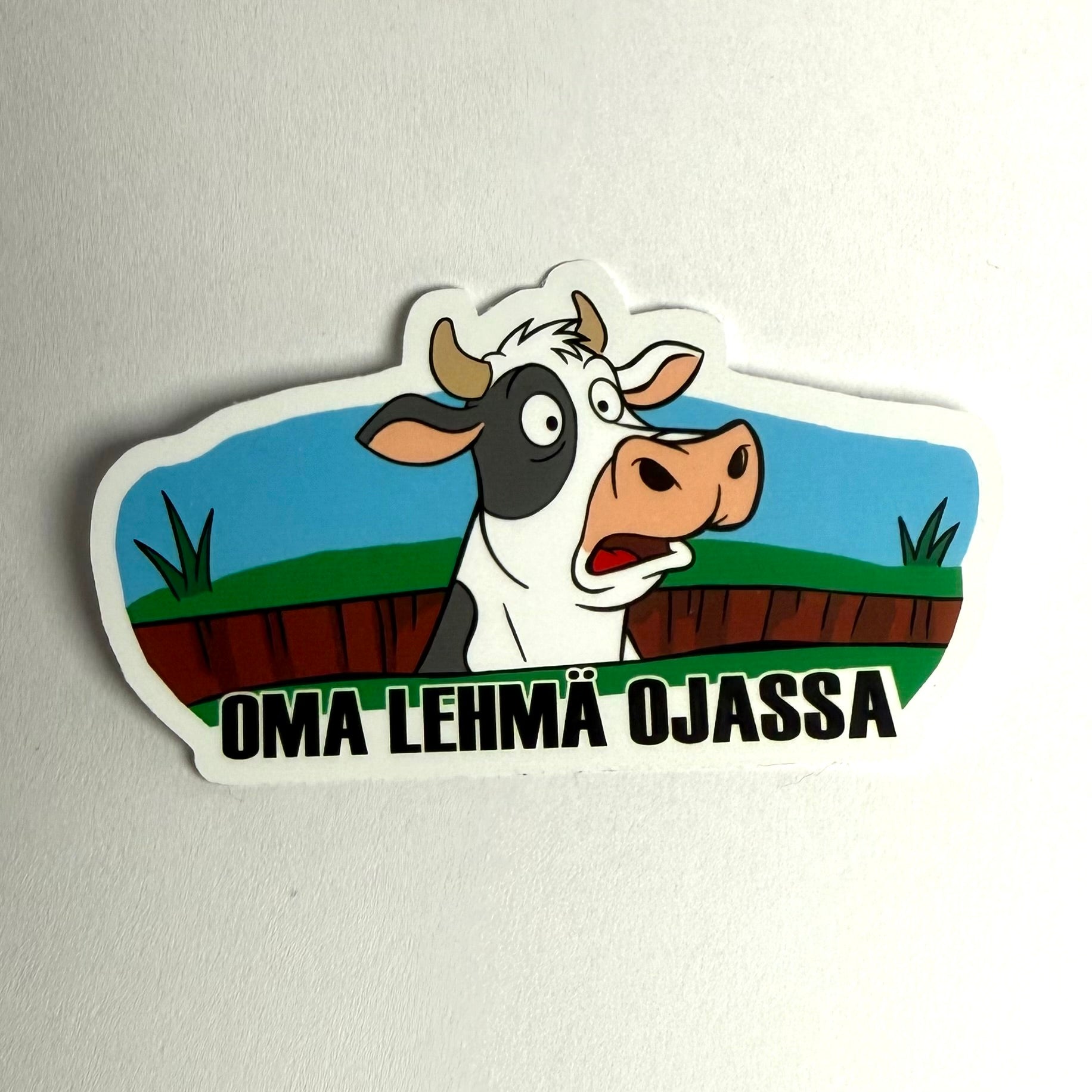 Oma lehmä ojassa tarra